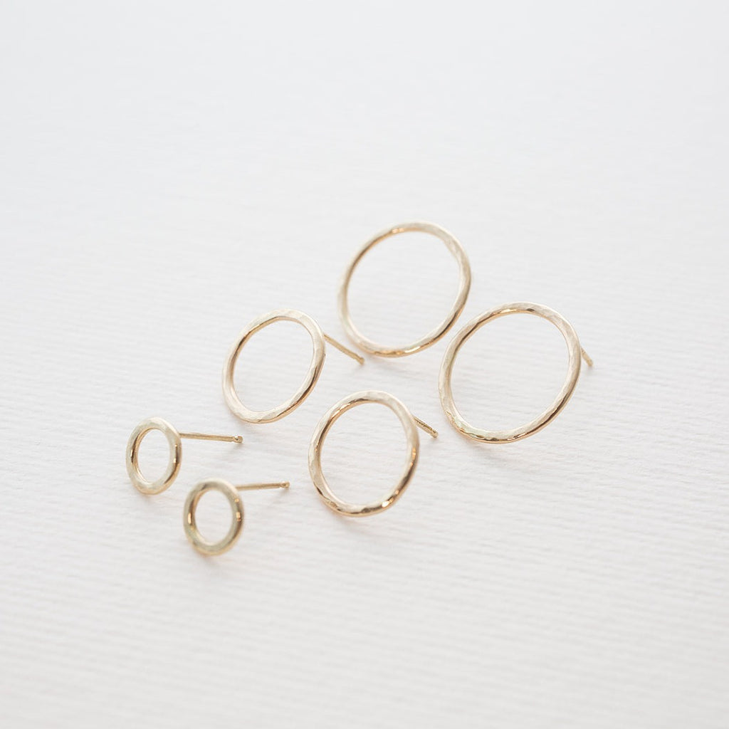 Handmade minimalist 14k solid gold 'Water Circle' stud earrings in a hammered finish shown in all three sizes