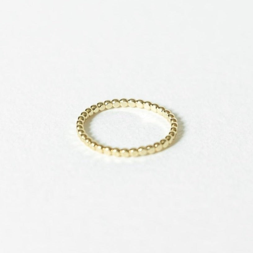 solid 14k gold beaded ring on white surface