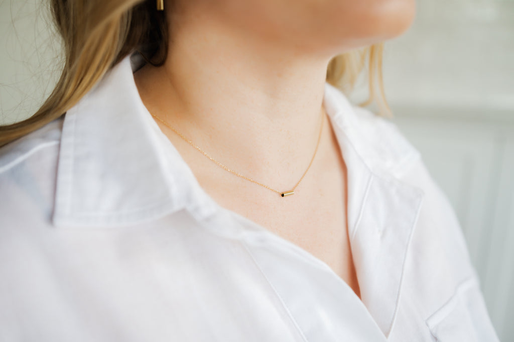Woman wearing minimalist solid gold chain with pendant