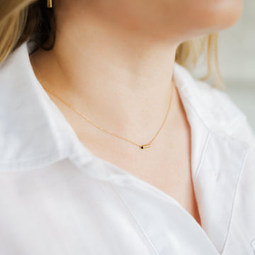 Woman wearing minimalist handmade 14k solid gold chain with bar pendant